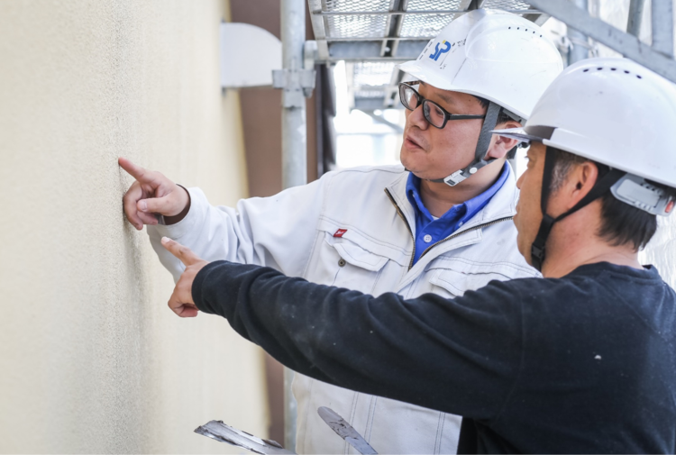 コーキング状態を確認する点検作業中のスタッフ