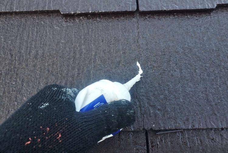 割れや欠けたスレート瓦を補修している写真