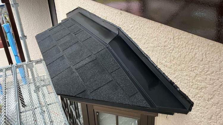 菊川市の住宅で金属庇にアスファルトシングルを重ね張りした施工後の写真。雨音対策として効果が高い工法。