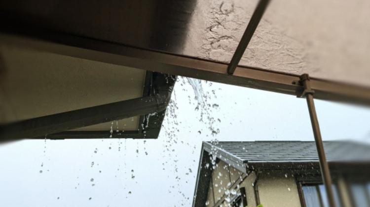 雨樋から水があふれ周りを濡らす様子